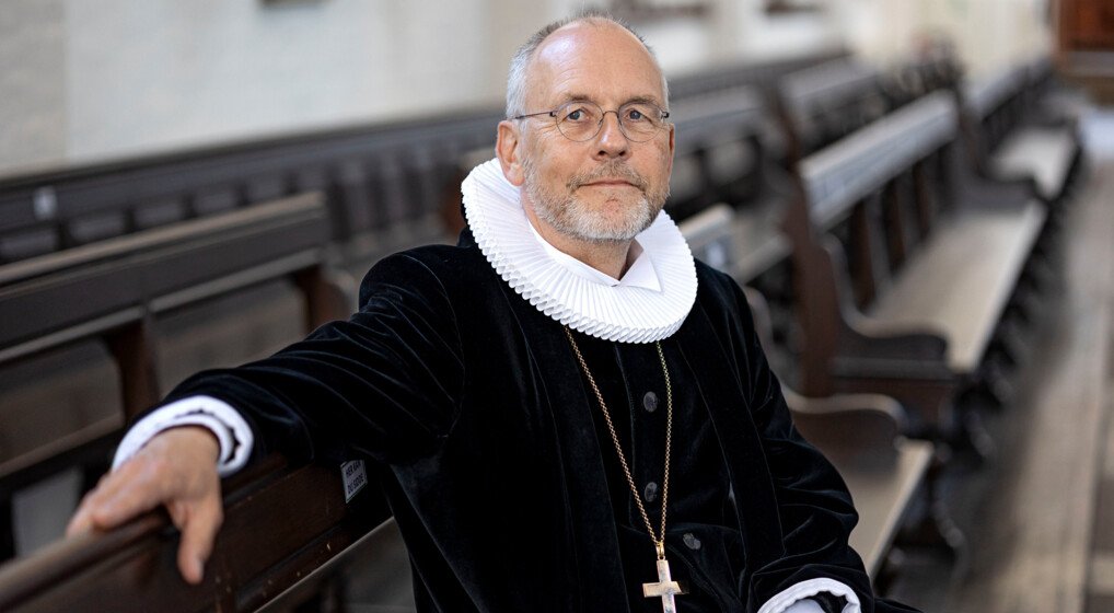 Portræt af biskop Henrik Wigh-Poulsen siddende på en kirkebænk i Aarhus domkirke
